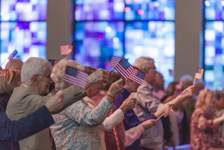 people in church waving American flags